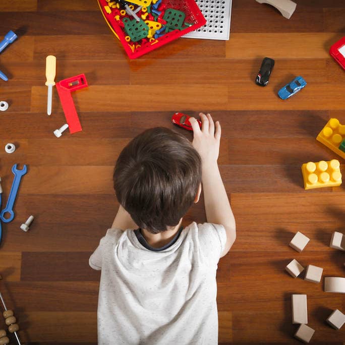 Child playing with toys on brown vinyl flooring